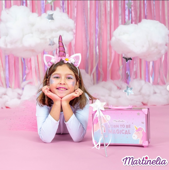 Niña con maletín de unicornio de maquillaje de Martinelia, disfrutando de la magia y fantasía de la cosmética infantil.